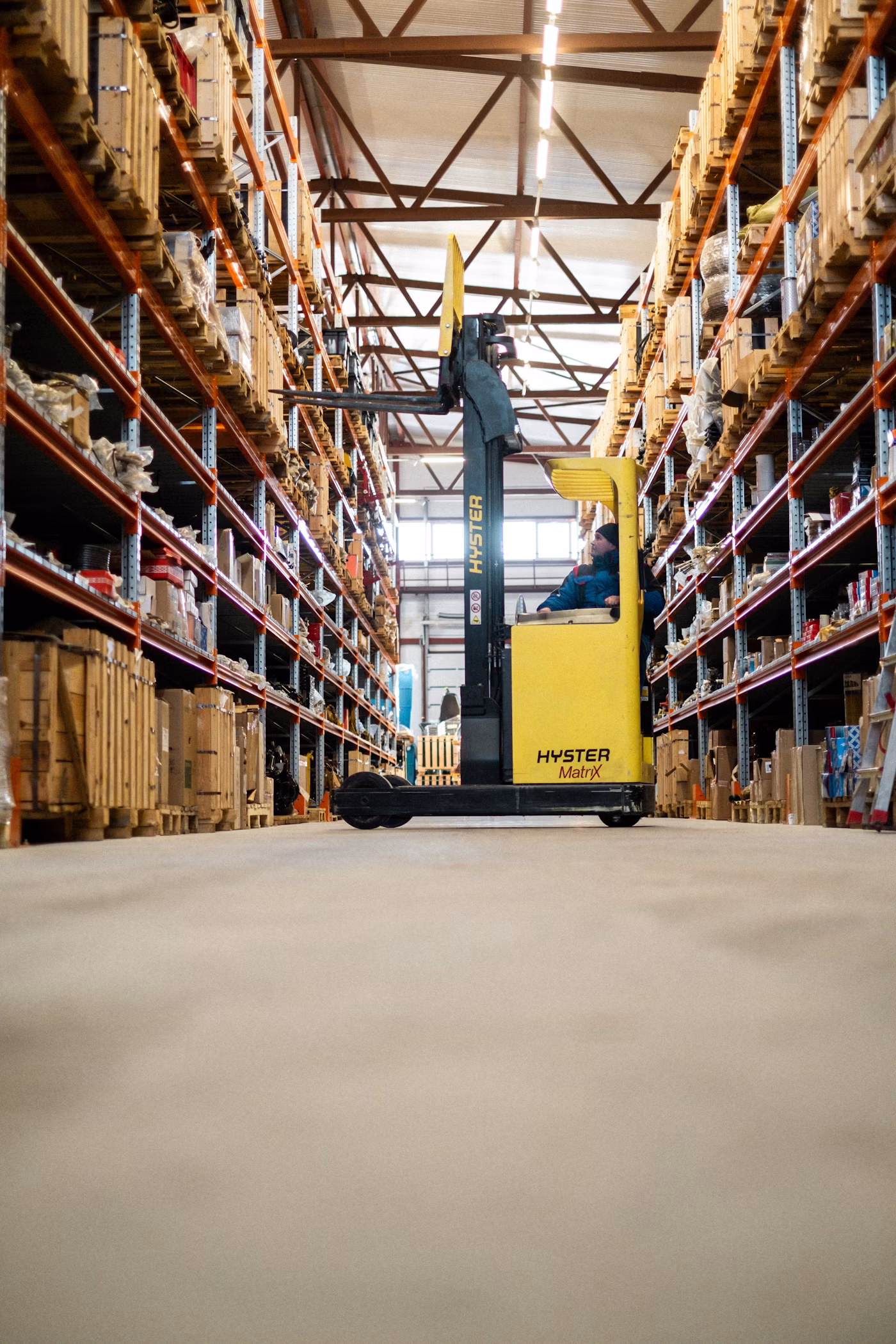 Warehouse worker retrieving inventory from a high shelf